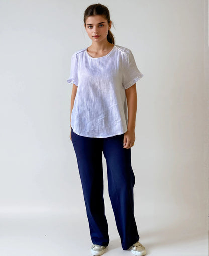 Femme enceinte portant le pantalon Cosy bleu marine, coupe droite et taille haute douce, debout de face, sur fond studio blanc.
